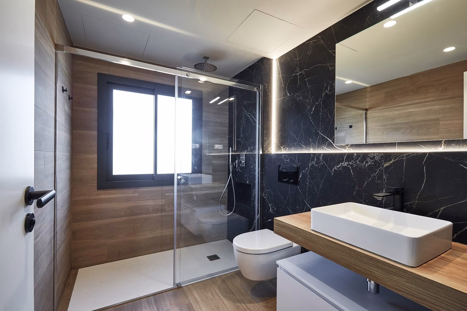 Baño con ducha junto a ventana y pared oscura veteada