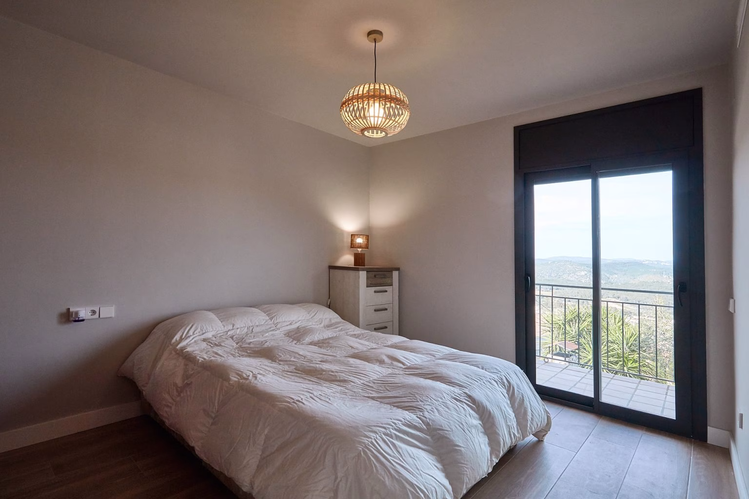 Dormitorio con balcón y suelo de tono madera