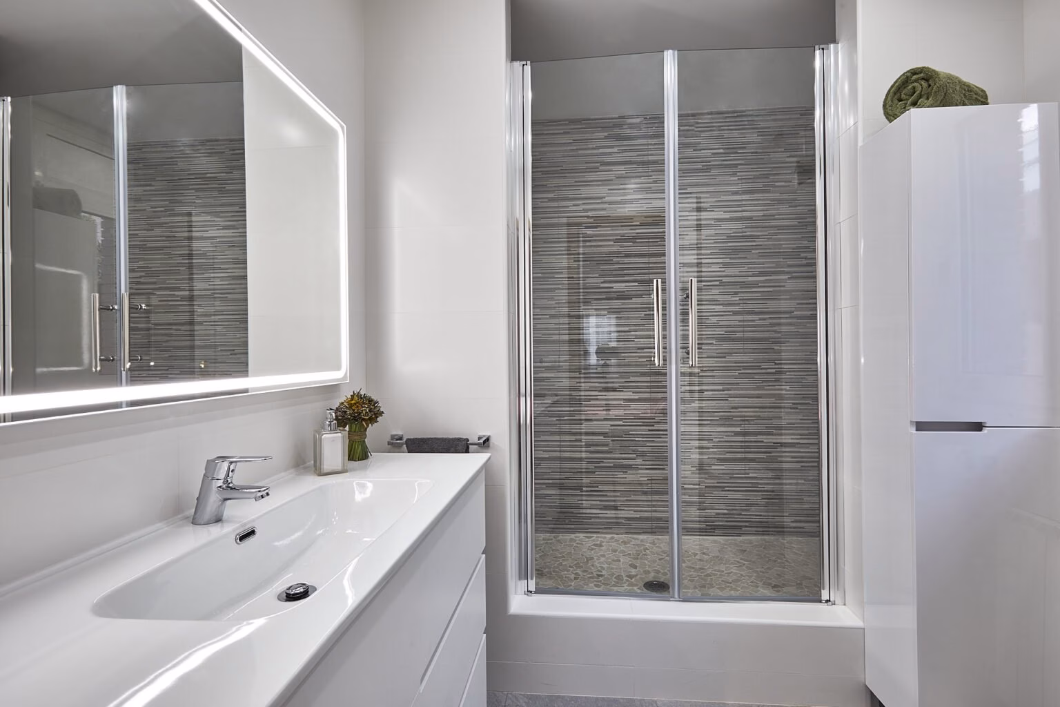 Lavabo y ducha con pared de piezas grises estrechas