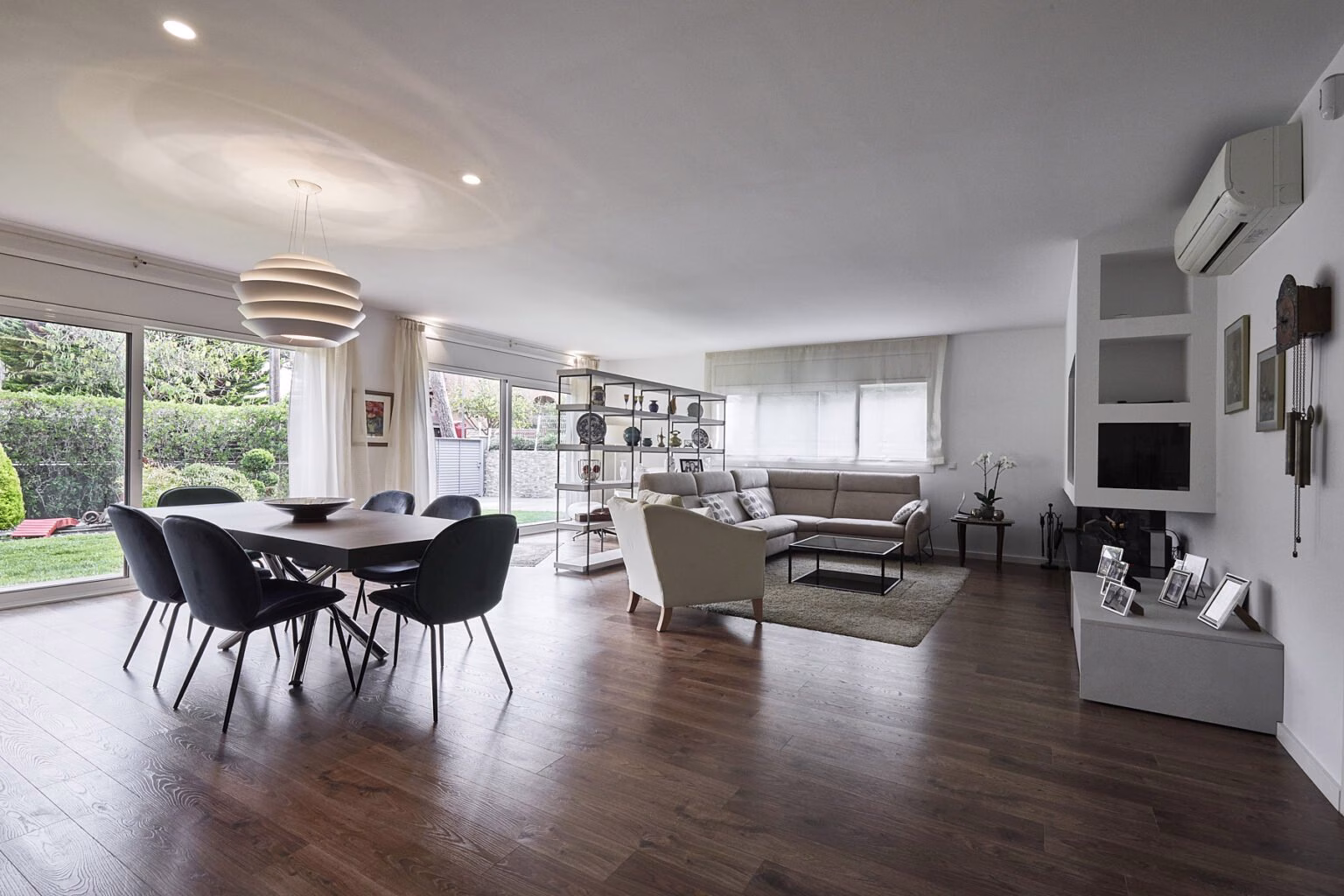 Salón y comedor junto a ventanales al jardín