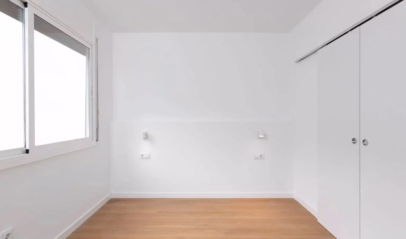 Frente de armario blanco junto a ventana
