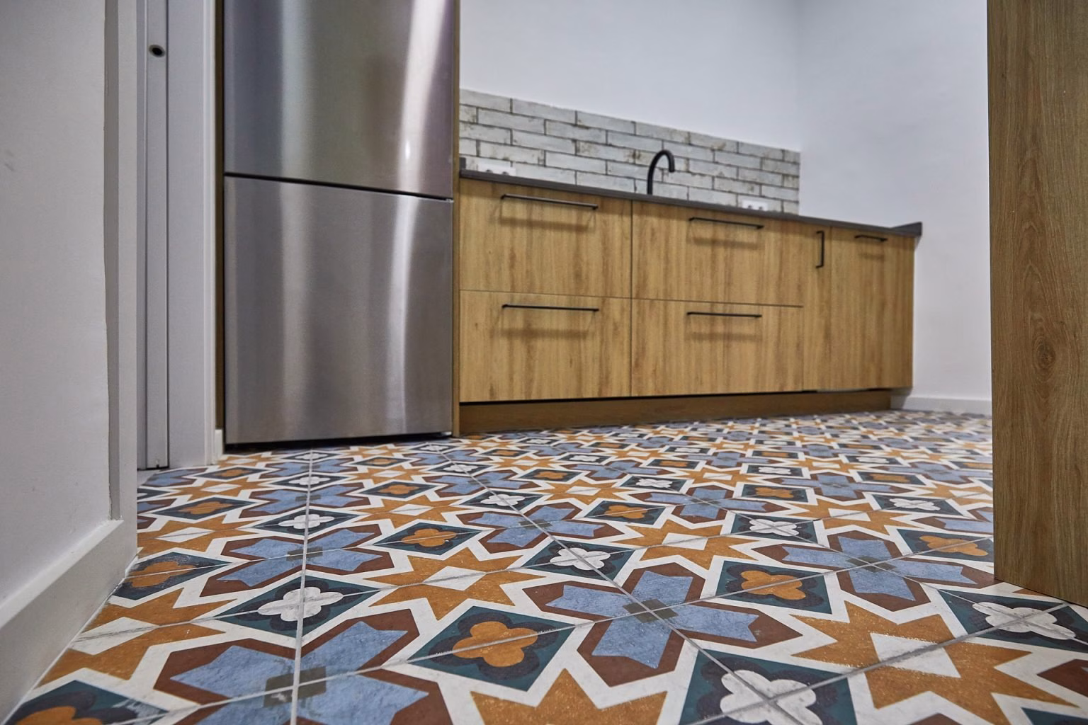 Pavimento geométrico bajo muebles de cocina