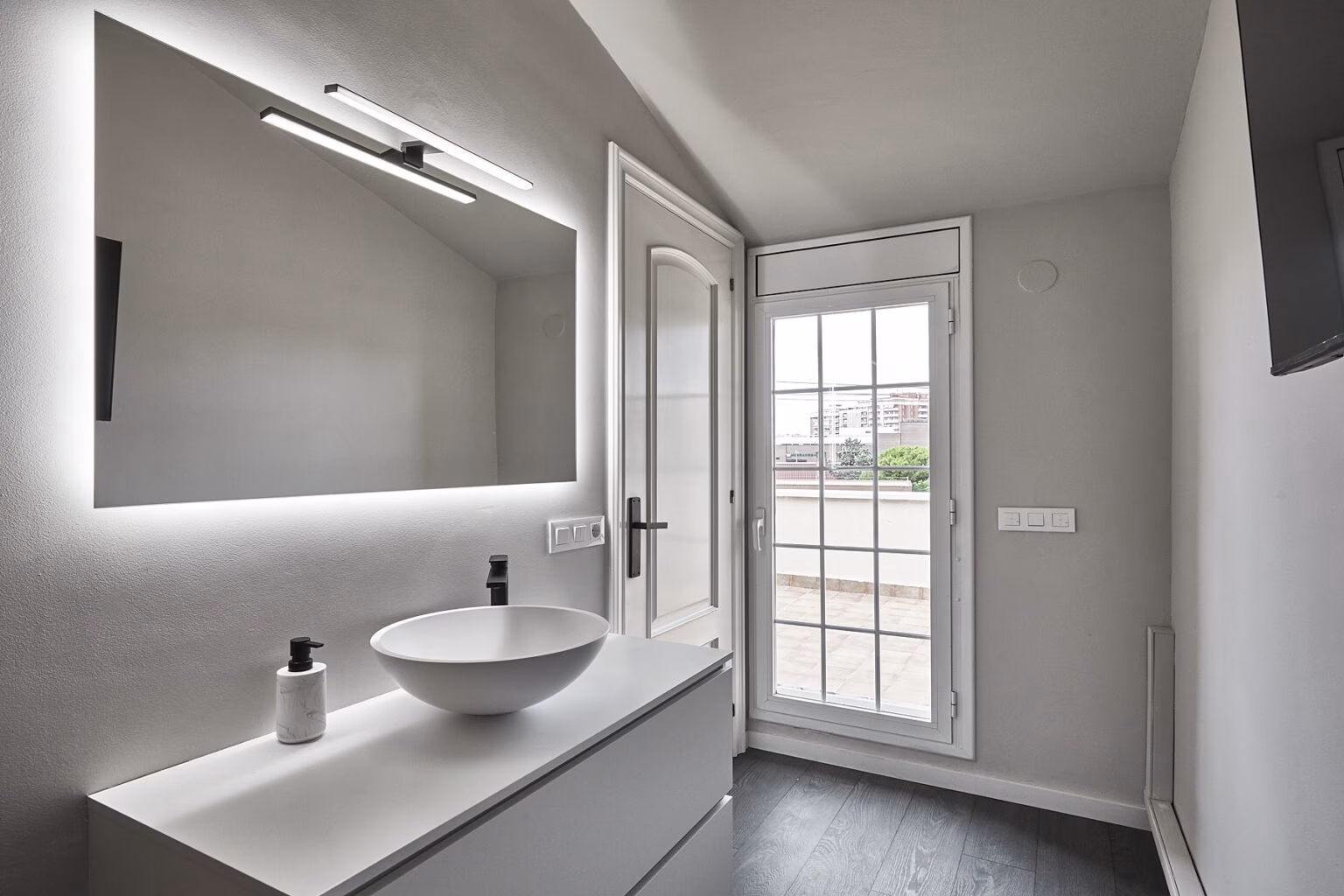 Lavabo de sobreencimera junto a puerta acristalada