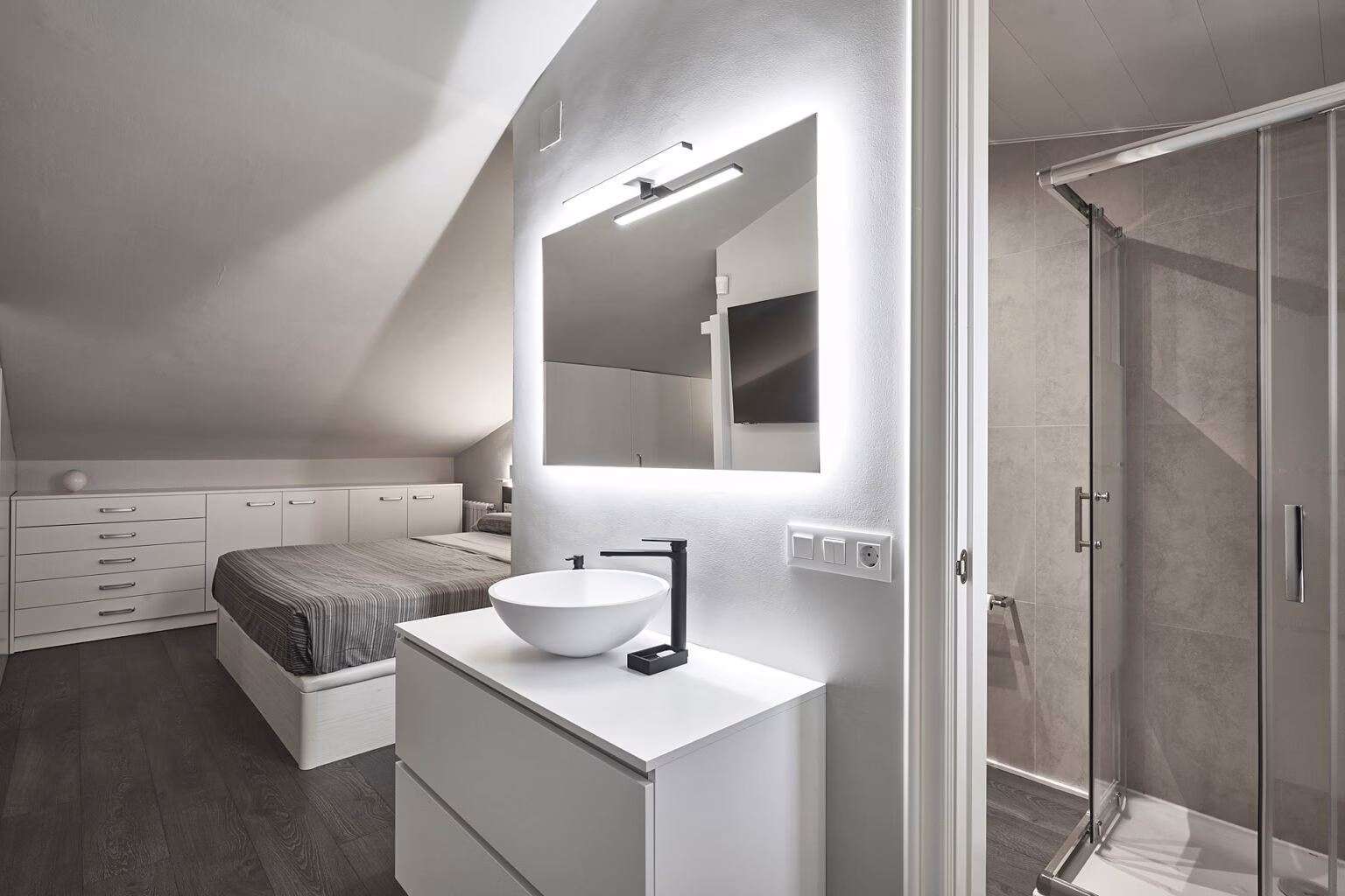 Lavabo junto a dormitorio abuhardillado y acceso a ducha