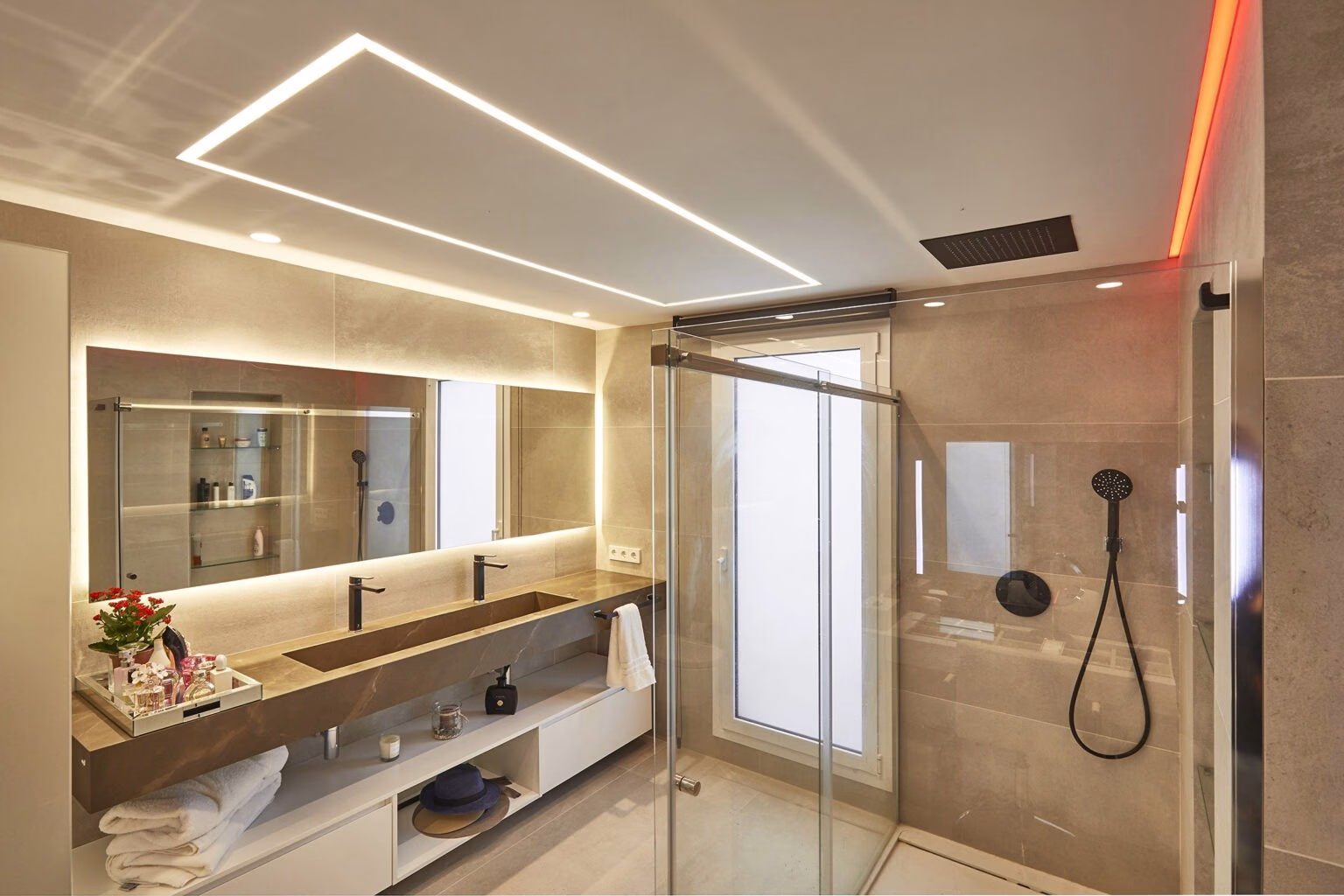 Baño con líneas de luz en el techo y encimera alargada