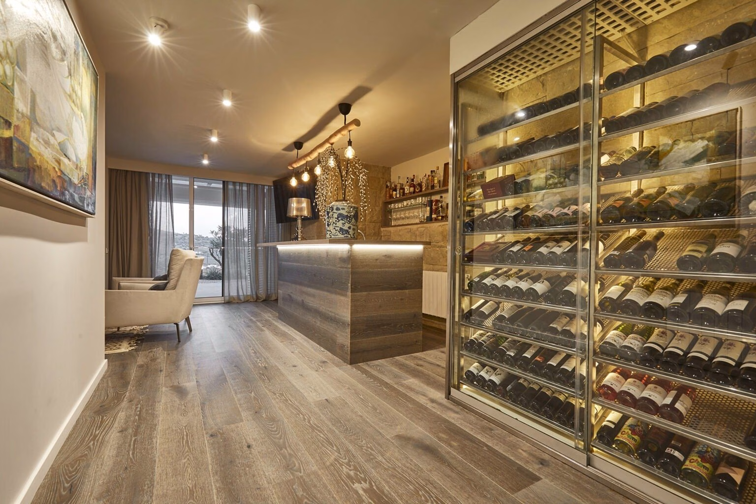 Zona de vinos con botellas tras vidrio iluminado