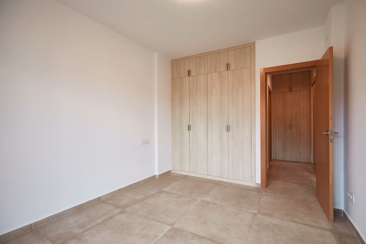 Dormitorio con armario empotrado de acabado madera