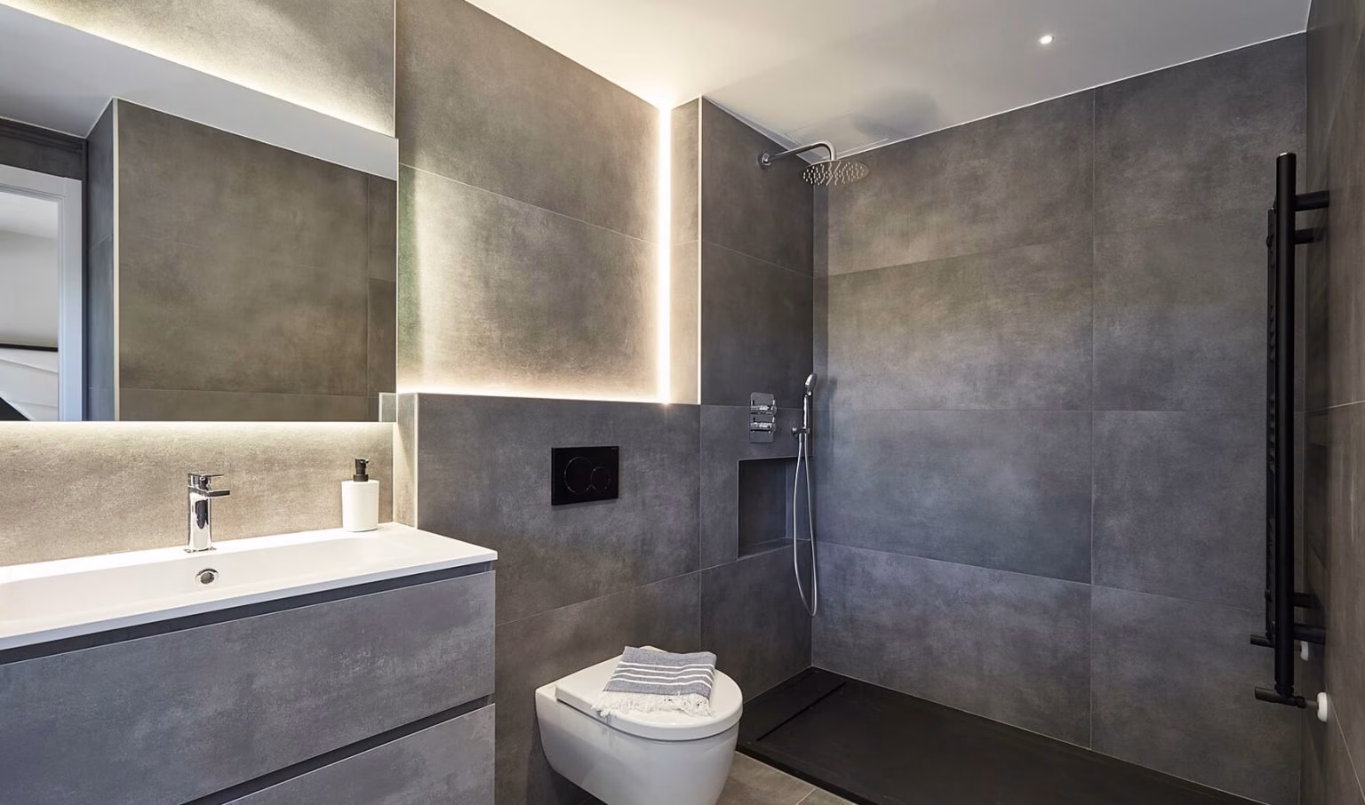 Baño gris con lavabo suspendido y ducha abierta