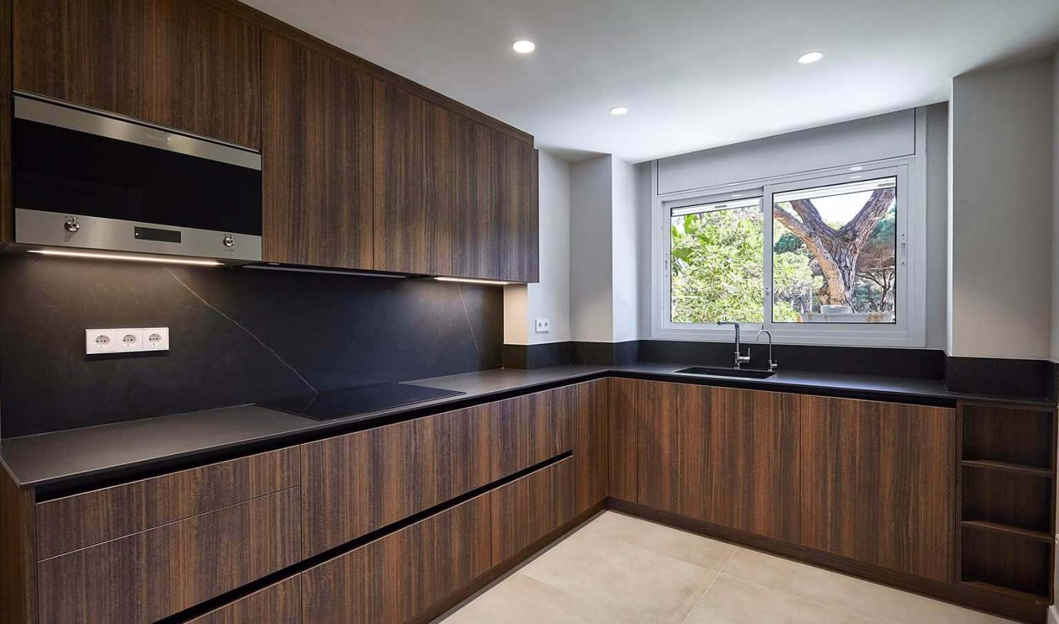 Cocina oscura en L con fregadero bajo ventana