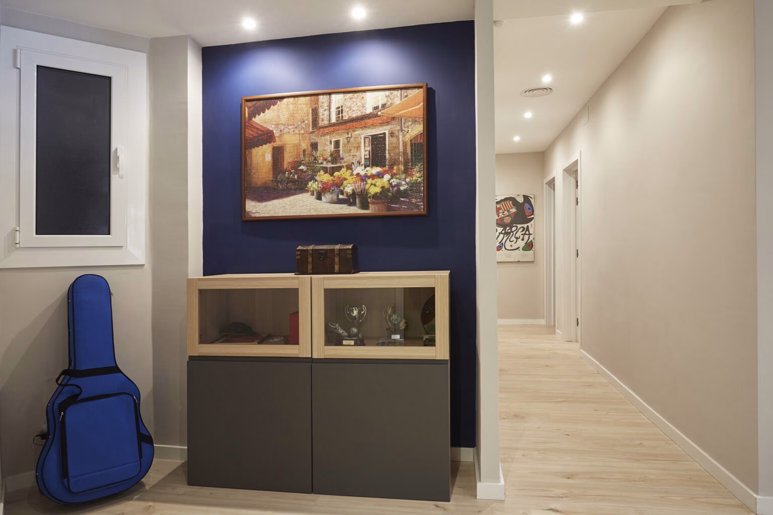 Mueble vitrina ante pared azul del recibidor