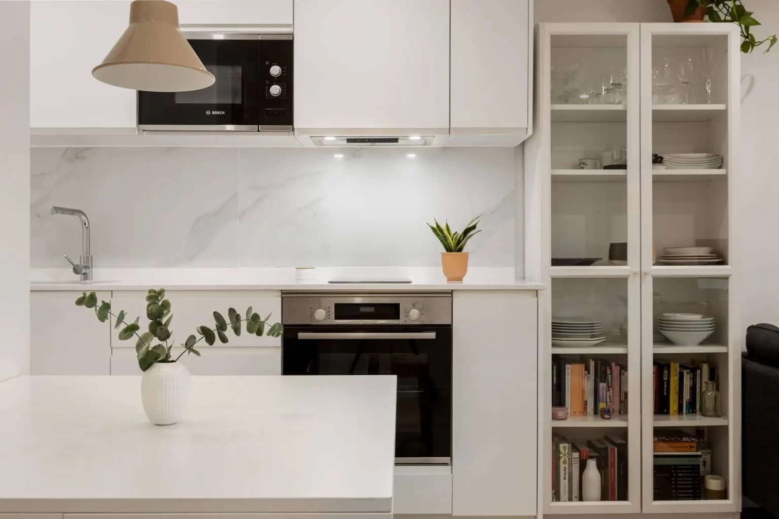 Cocina blanca con horno y vitrina abierta