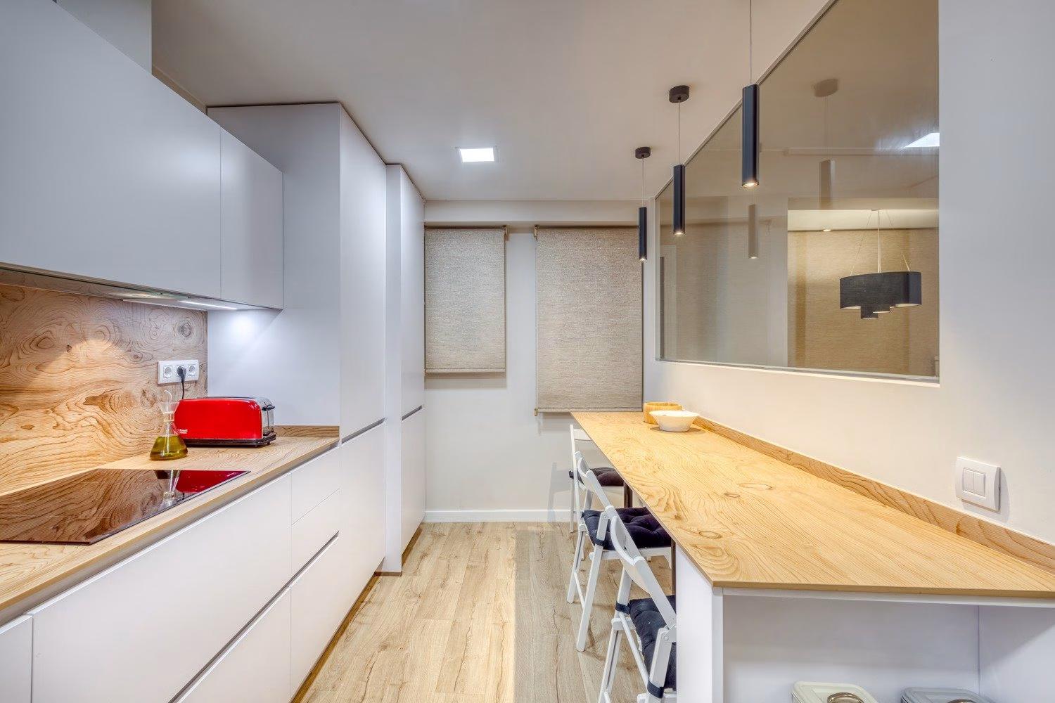 Cocina alargada con barra lateral y cerramiento acristalado
