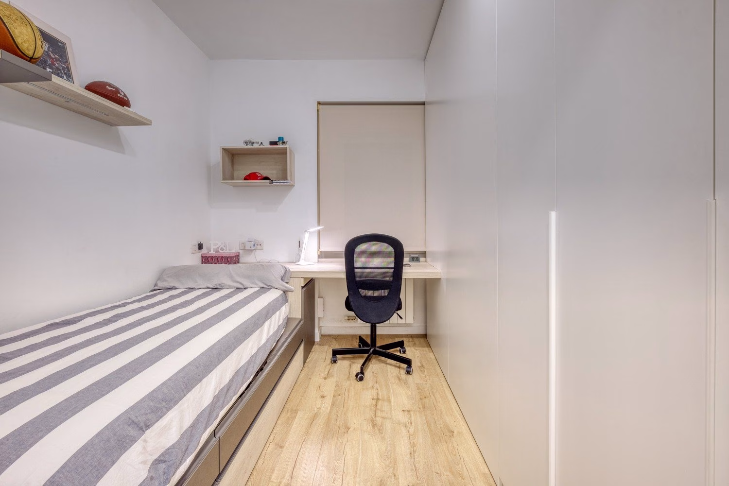 Dormitorio individual con escritorio junto a cama