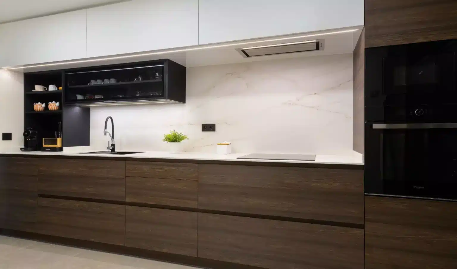Cocina con muebles de veta oscura y vitrina negra horizontal