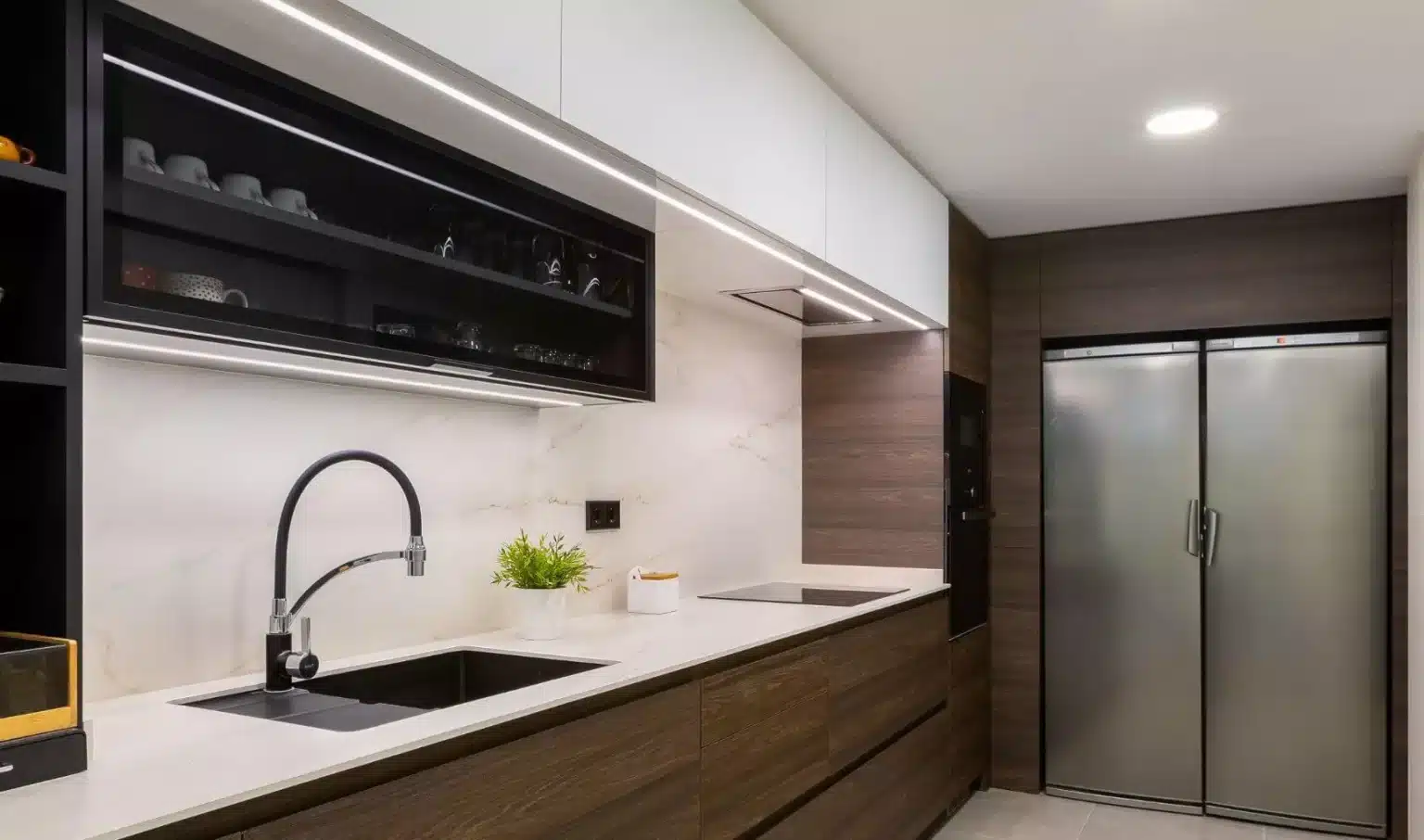 Encimera clara con fregadero negro y frigorífico de doble puerta