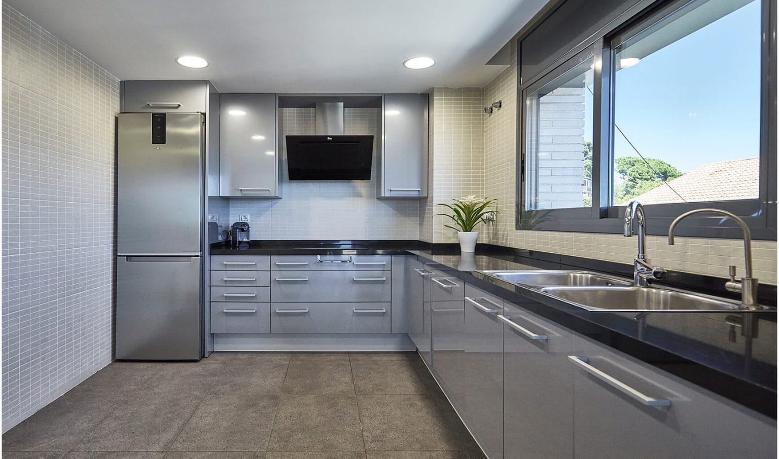 Cocina gris en L con ventana alargada