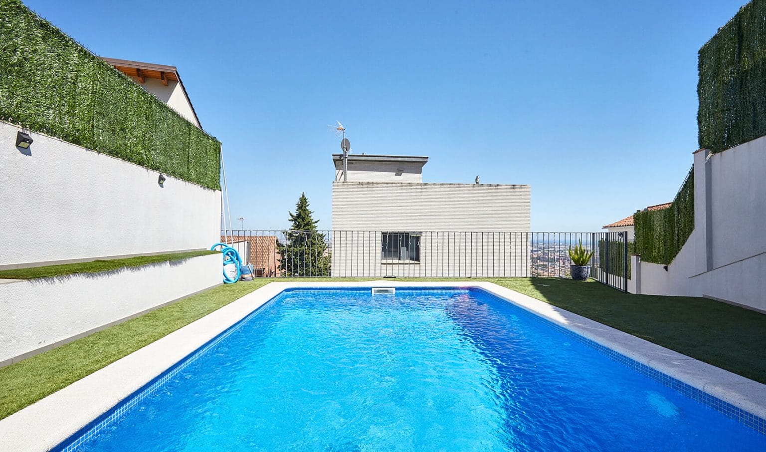 Piscina longitudinal entre muros claros