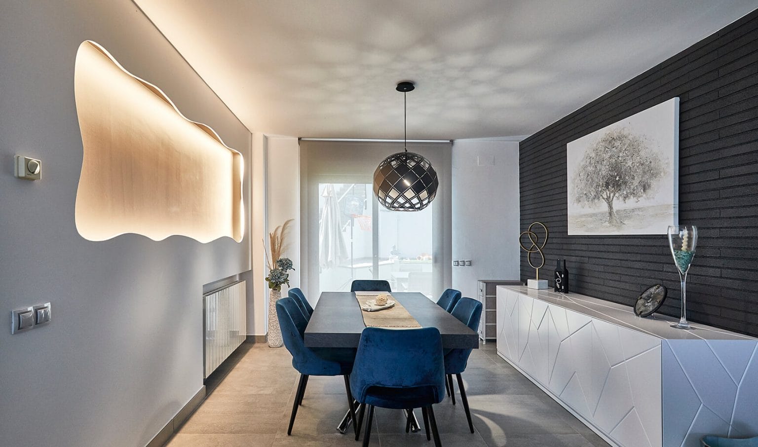Comedor con sillas azules y panel iluminado