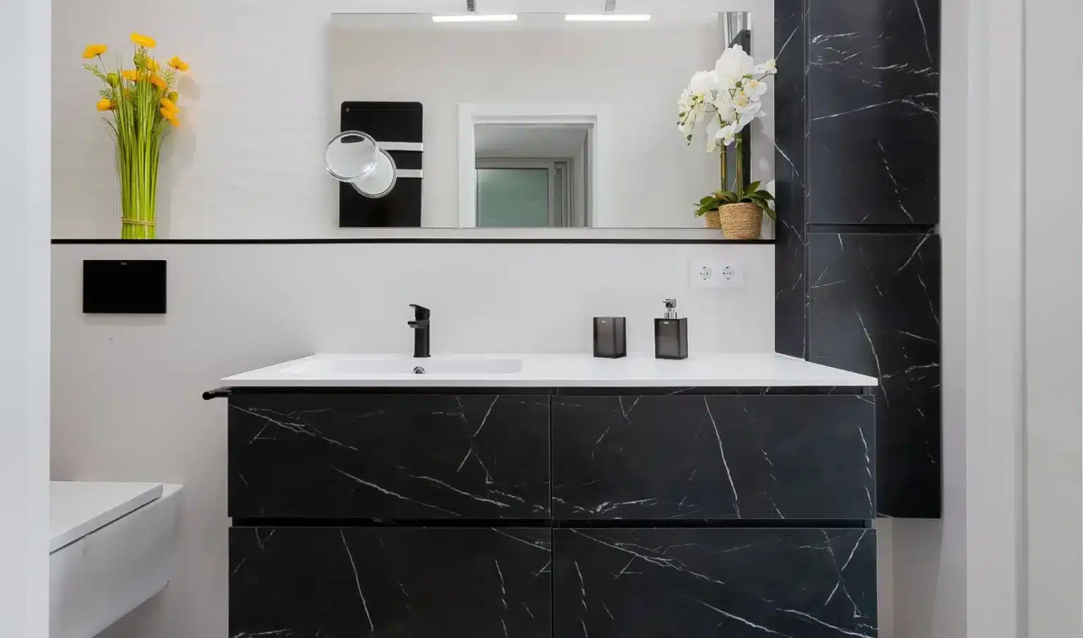 Lavabo blanco sobre mueble oscuro veteado