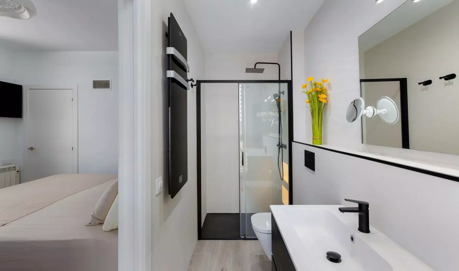 Baño blanco alargado con ducha de perfiles negros